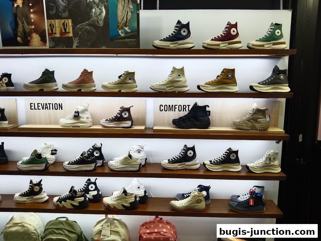 A display of various Converse sneakers on shelves, showcasing different styles and colors.