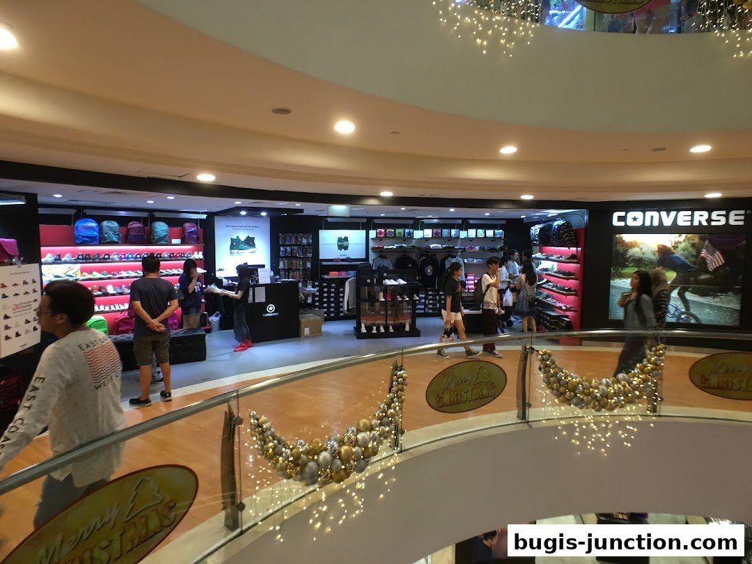 Interior view of a Converse store showcasing shoes, backpacks, and apparel with customers browsing.