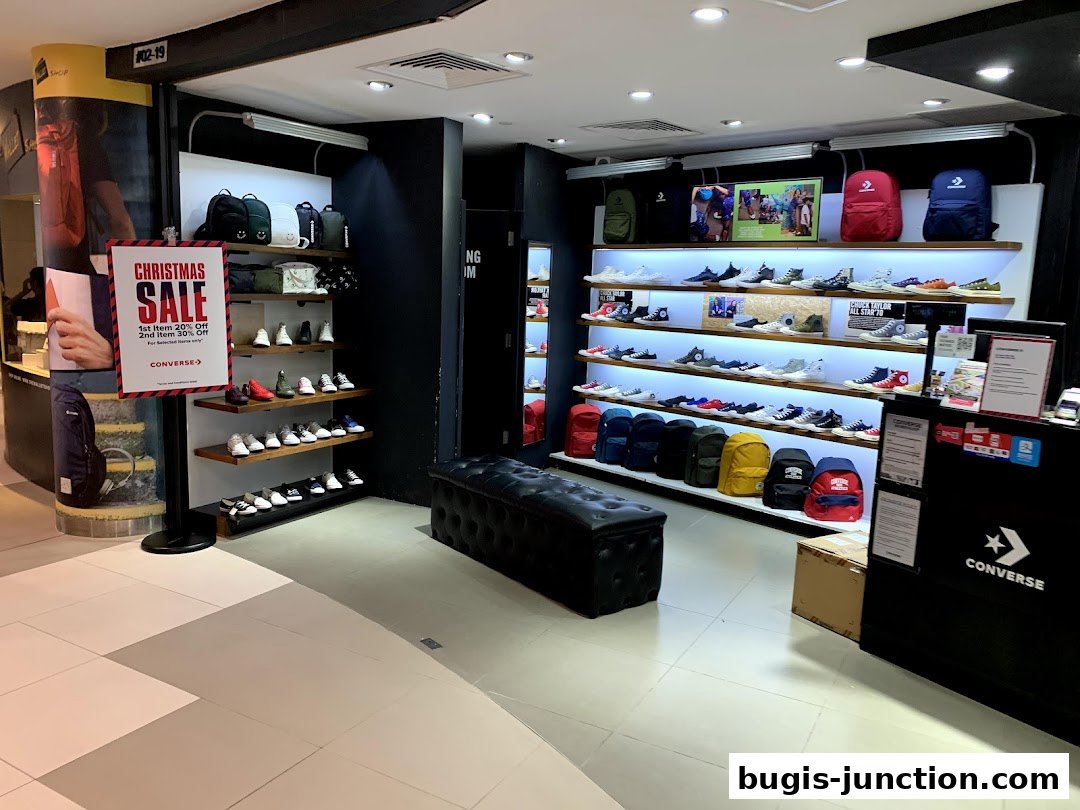 Interior of a Converse store showcasing shelves of sneakers and backpacks, with a Christmas sale sign.