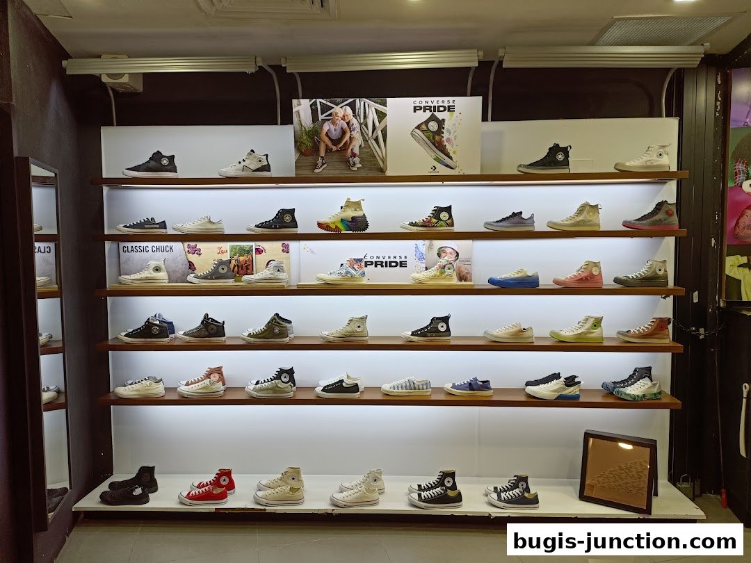 A well-lit display of Converse sneakers on multiple shelves, showcasing various styles and colors.