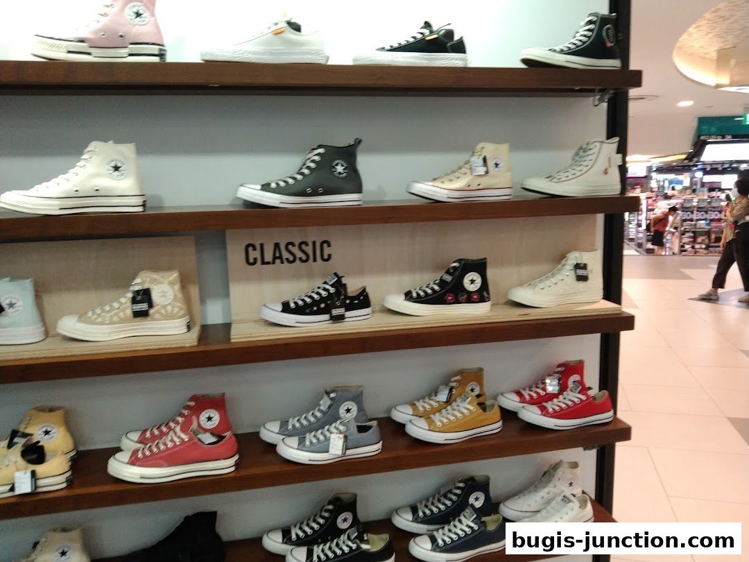 Shelves filled with various styles and colors of Converse sneakers.