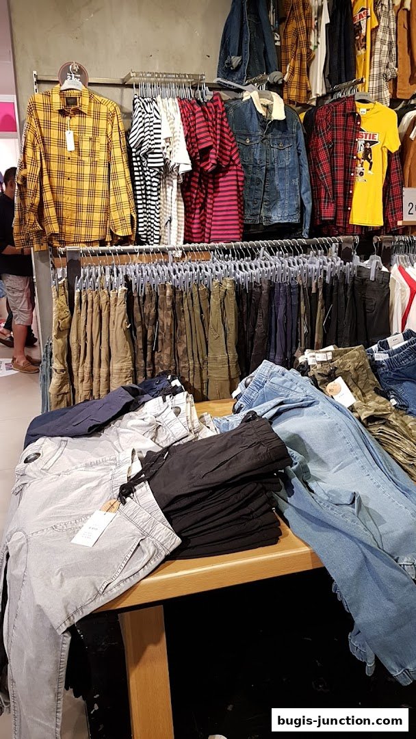 A display of casual clothing including shirts, jackets, and pants at Cotton On.