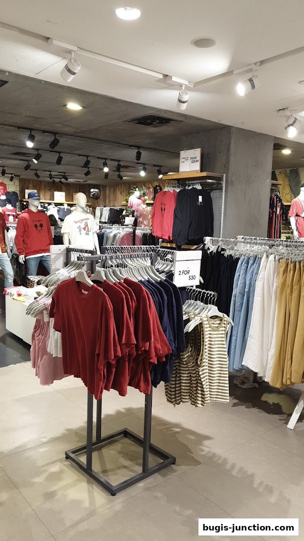 Interior view of a Cotton On and Rubi clothing store with racks of apparel.