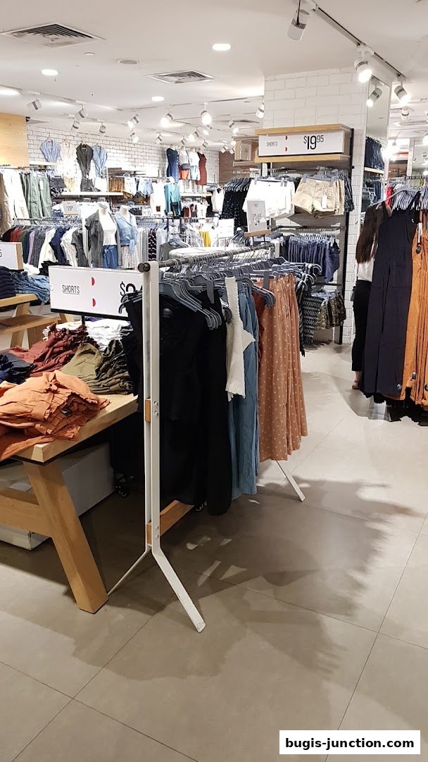 Interior view of a clothing store with racks of apparel and mannequins.