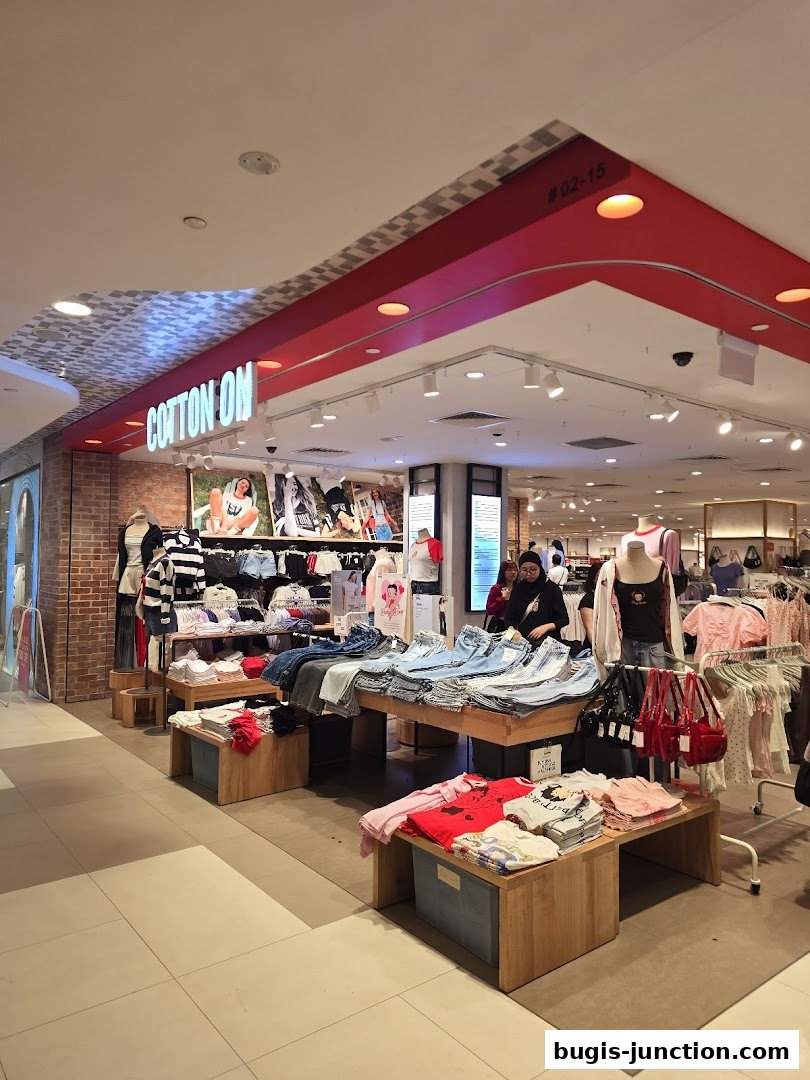 Interior view of a Cotton On and Rubi clothing store with displays of jeans, t-shirts, and accessories.