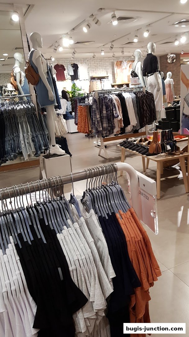 Interior view of a Cotton On and Rubi clothing store with mannequins and racks of apparel.