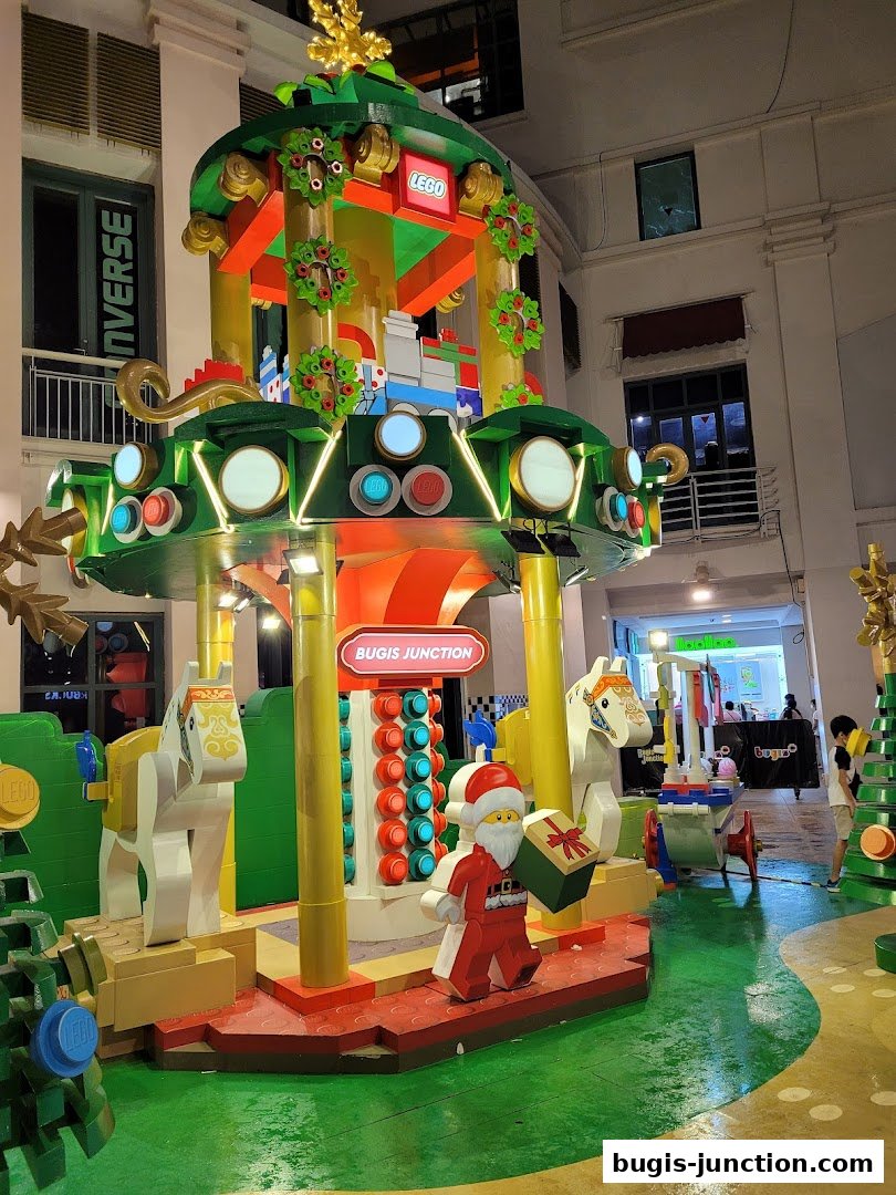 A festive Lego-themed Christmas display with Santa, horses, and a carousel structure.
