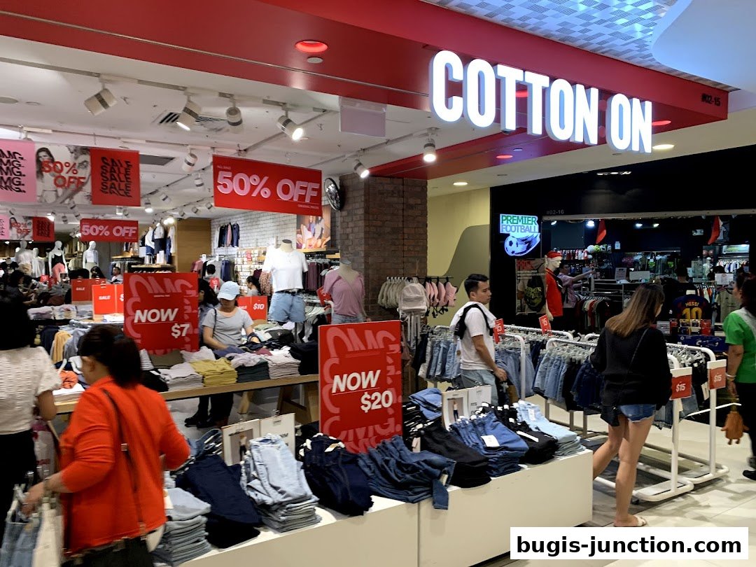 Interior of a Cotton On store with sale signs and clothing displays.