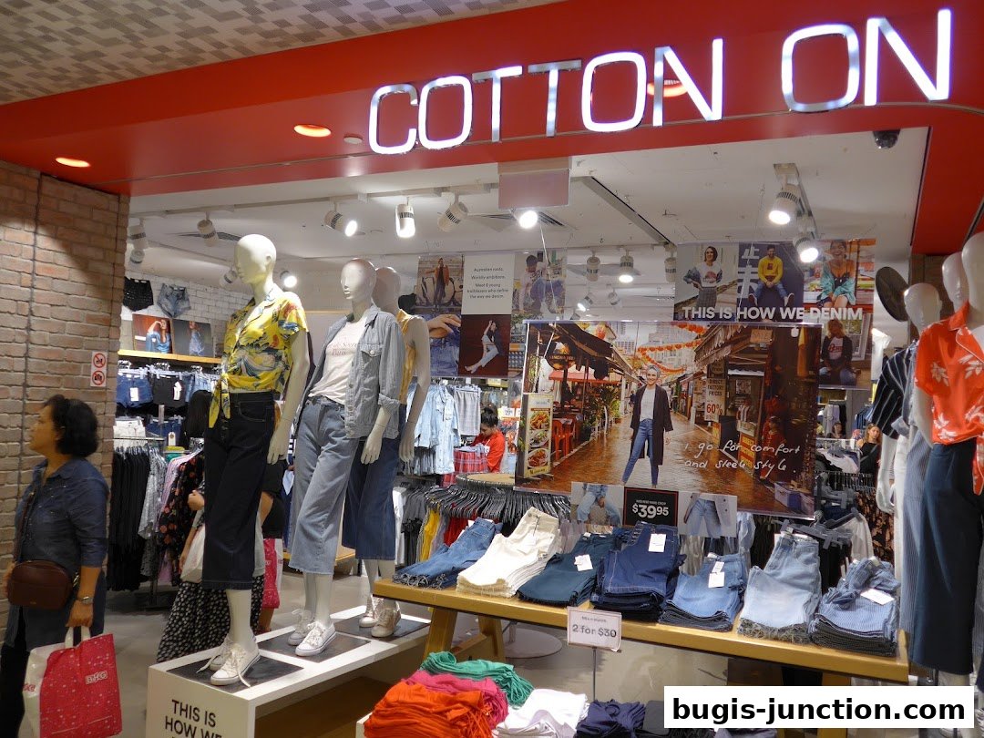 Cotton On RUBI shop interior with mannequins displaying denim fashion and clothing racks.