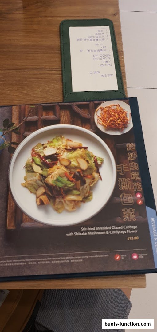 A menu featuring a dish of stir-fried shredded glazed cabbage with mushrooms.