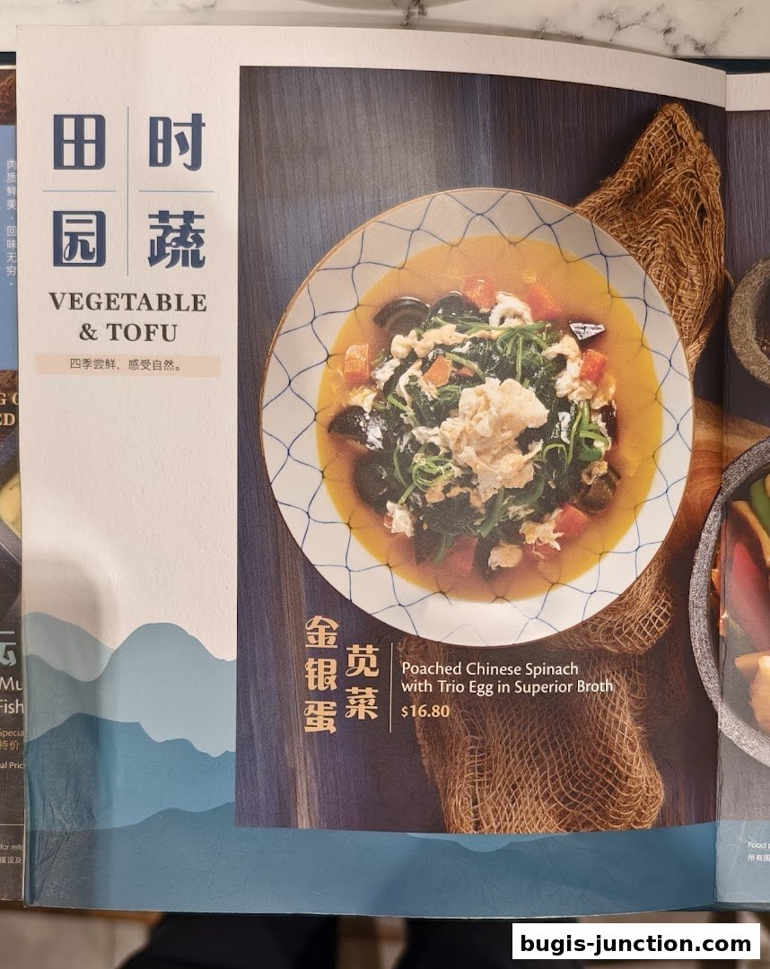A menu page featuring a dish of Poached Chinese Spinach with Trio Egg.