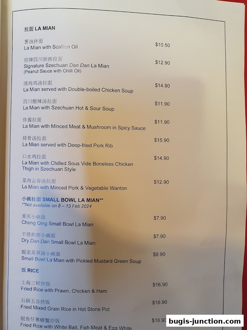 A menu from Crystal Jade La Mian Xiao Long Bao featuring various noodle and rice dishes.