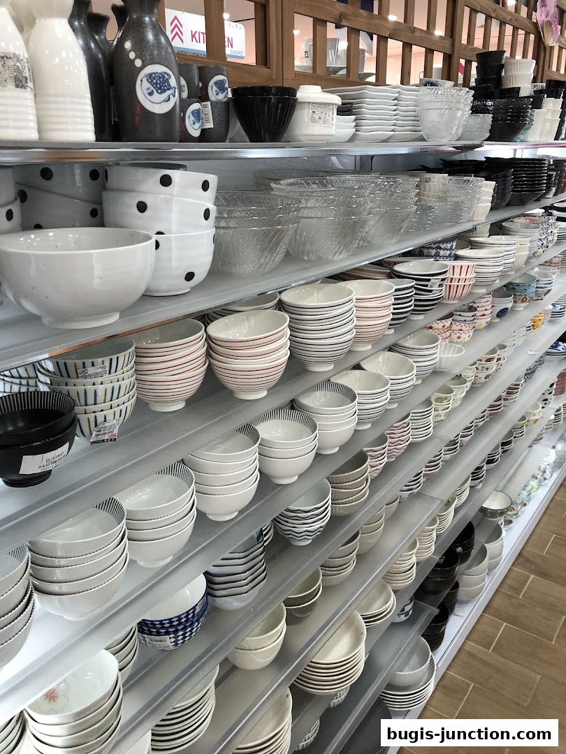 Shelves stocked with a wide variety of bowls, cups, and kitchenware in various designs.