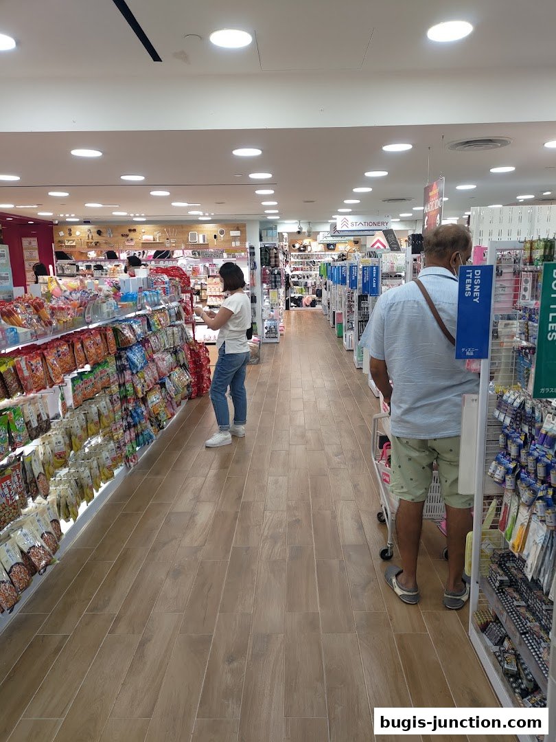 Interior view of a Daiso store with aisles of products and shoppers.