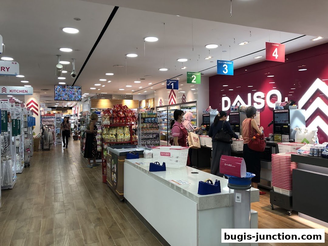 Interior view of a Daiso store with shoppers at the checkout counters and aisles stocked with products.