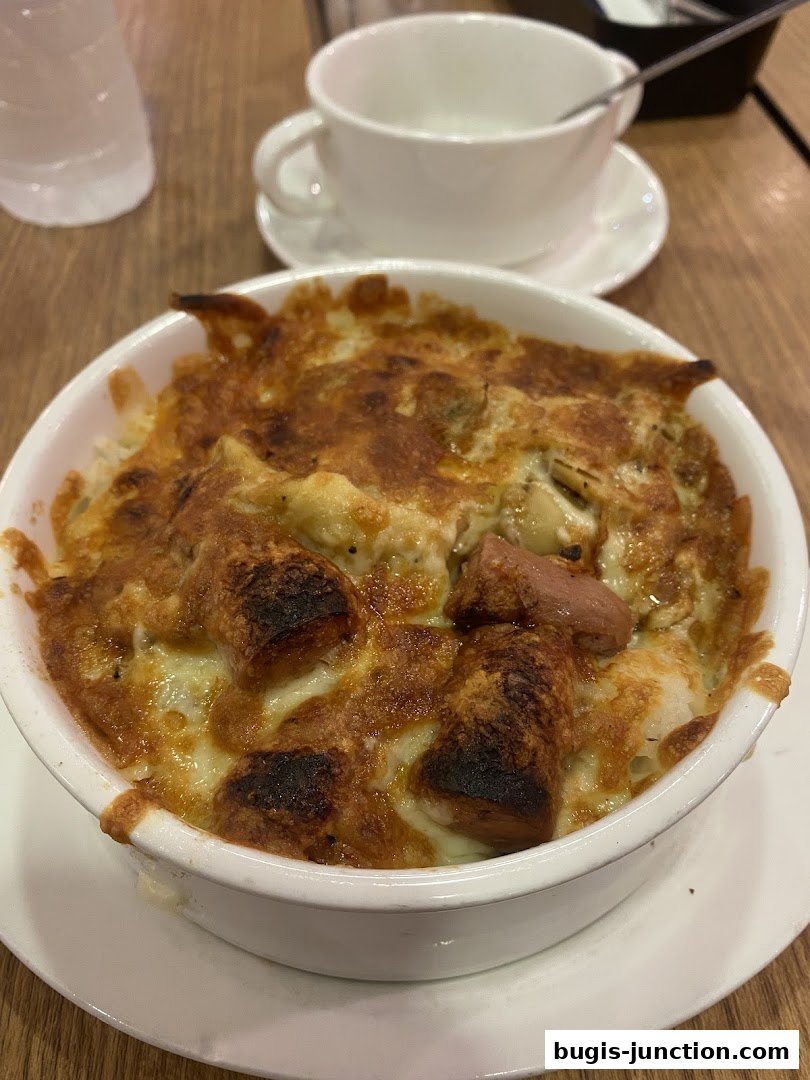 A close-up shot of a baked pasta dish with cheese and sausage.