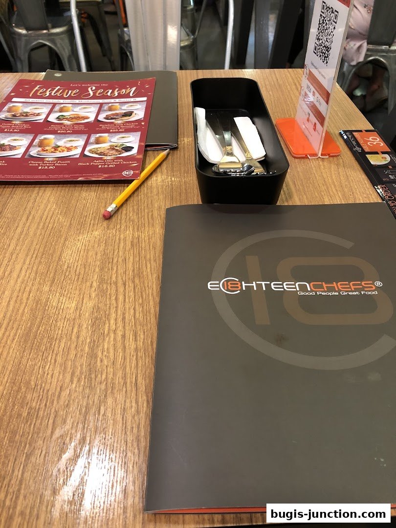 A table setting at Eighteen Chefs with a menu and cutlery holder.