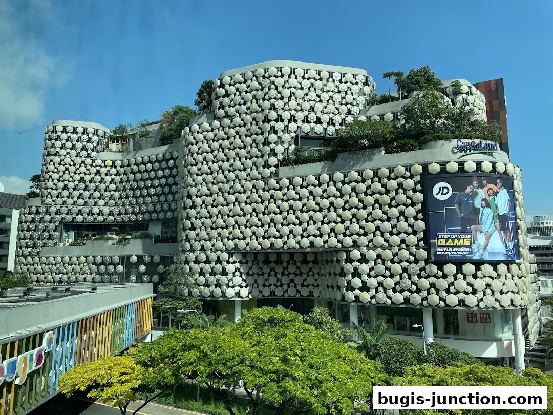 Exterior view of a uniquely designed building with a JD advertisement and Uniqlo store.