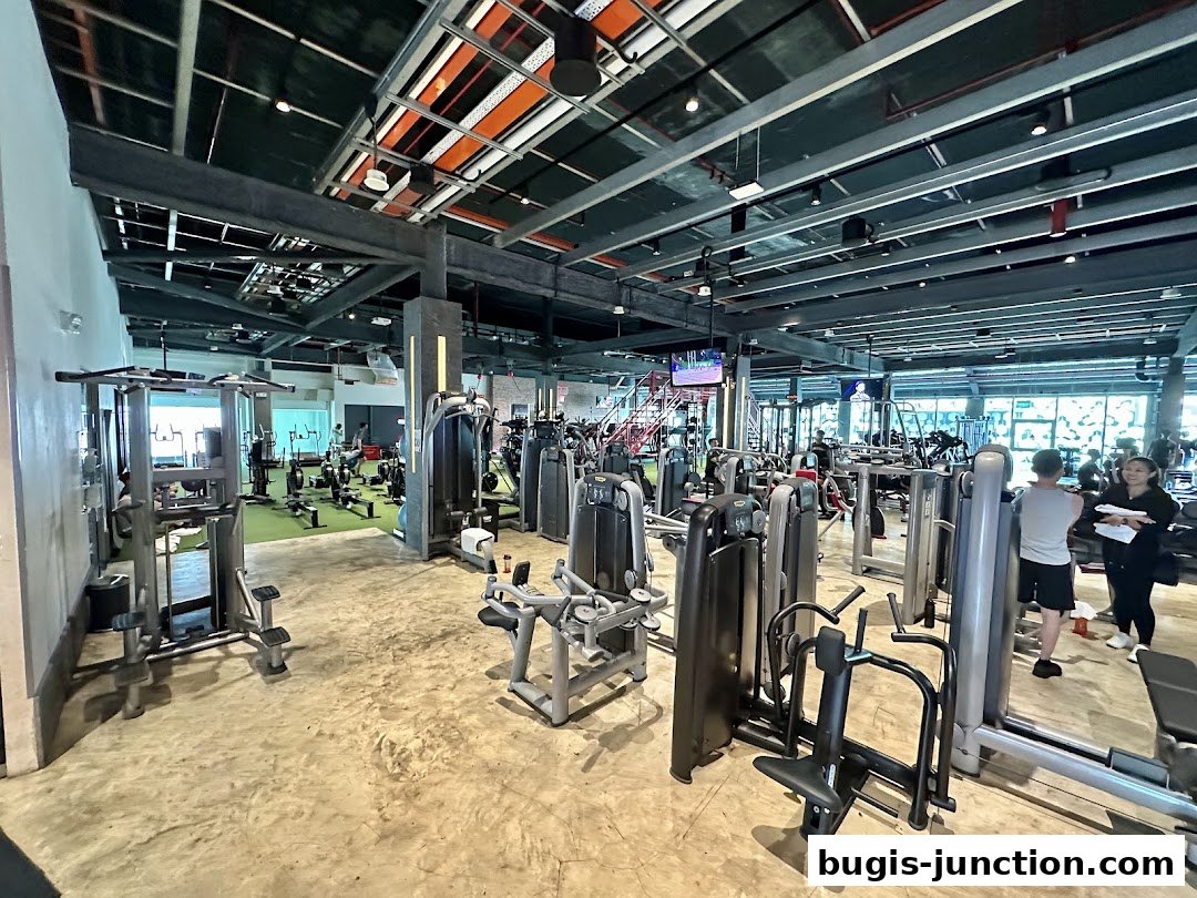 Interior view of a spacious, modern gym with various weight machines and cardio equipment.