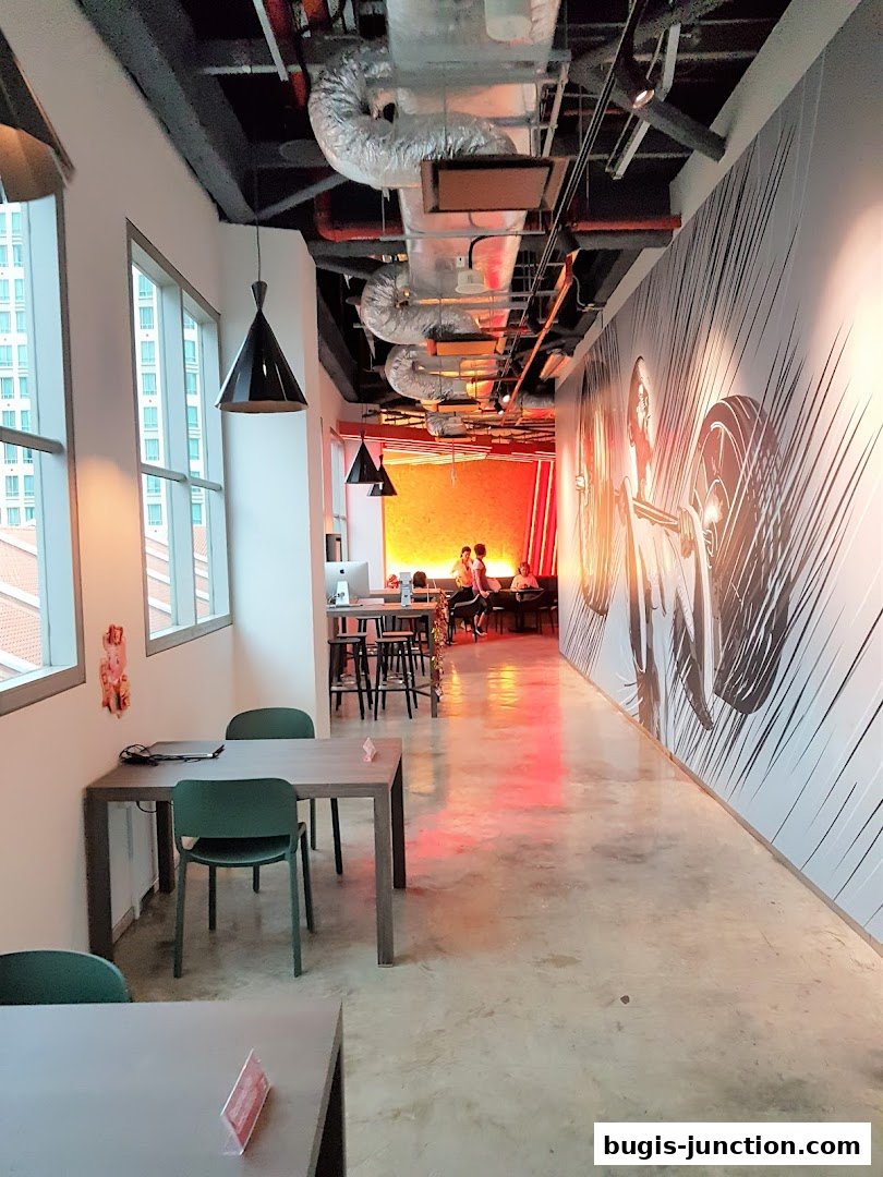 Interior of a modern fitness center with seating areas and artistic wall murals.