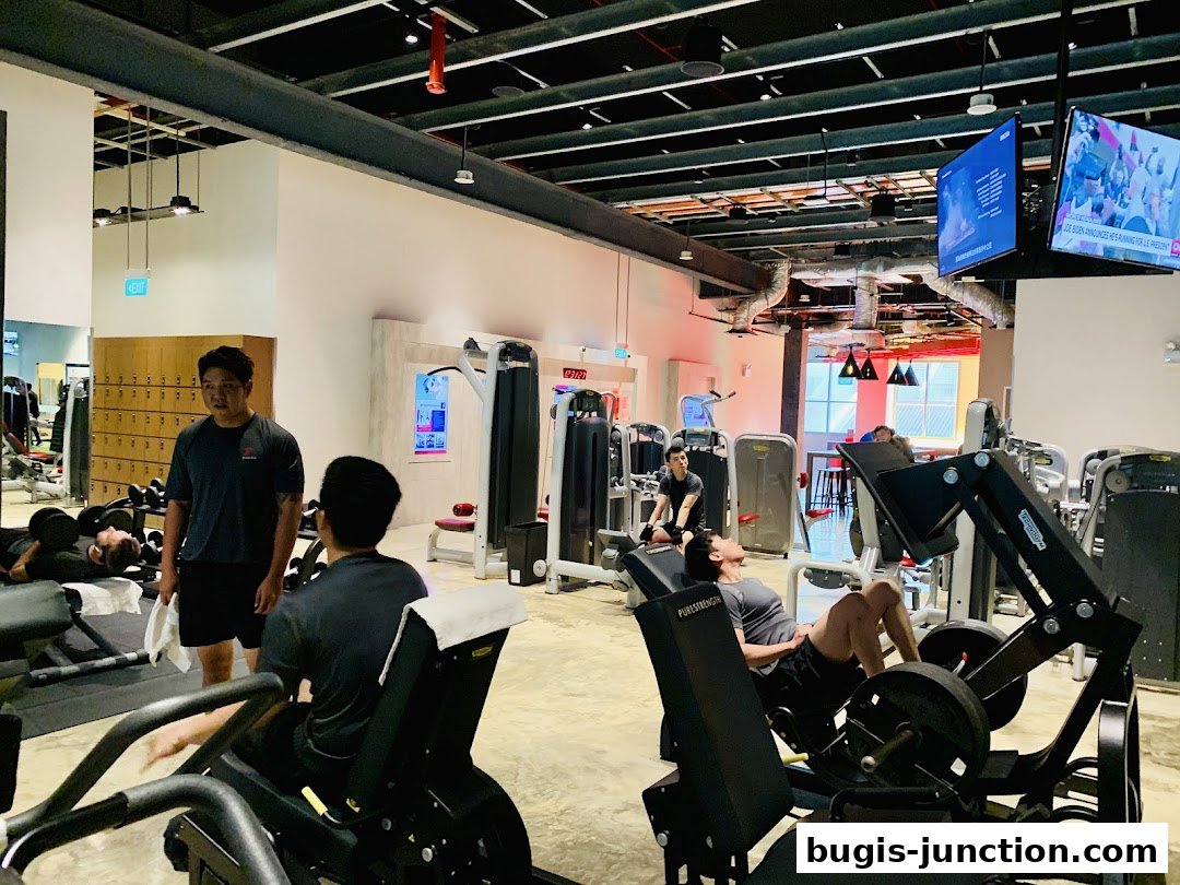 People working out on various gym equipment in a modern fitness center.