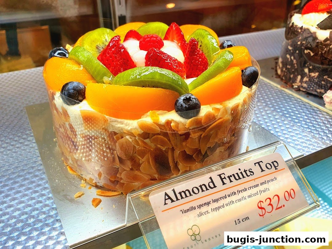 A beautifully decorated cake with fresh fruits and almonds on display.