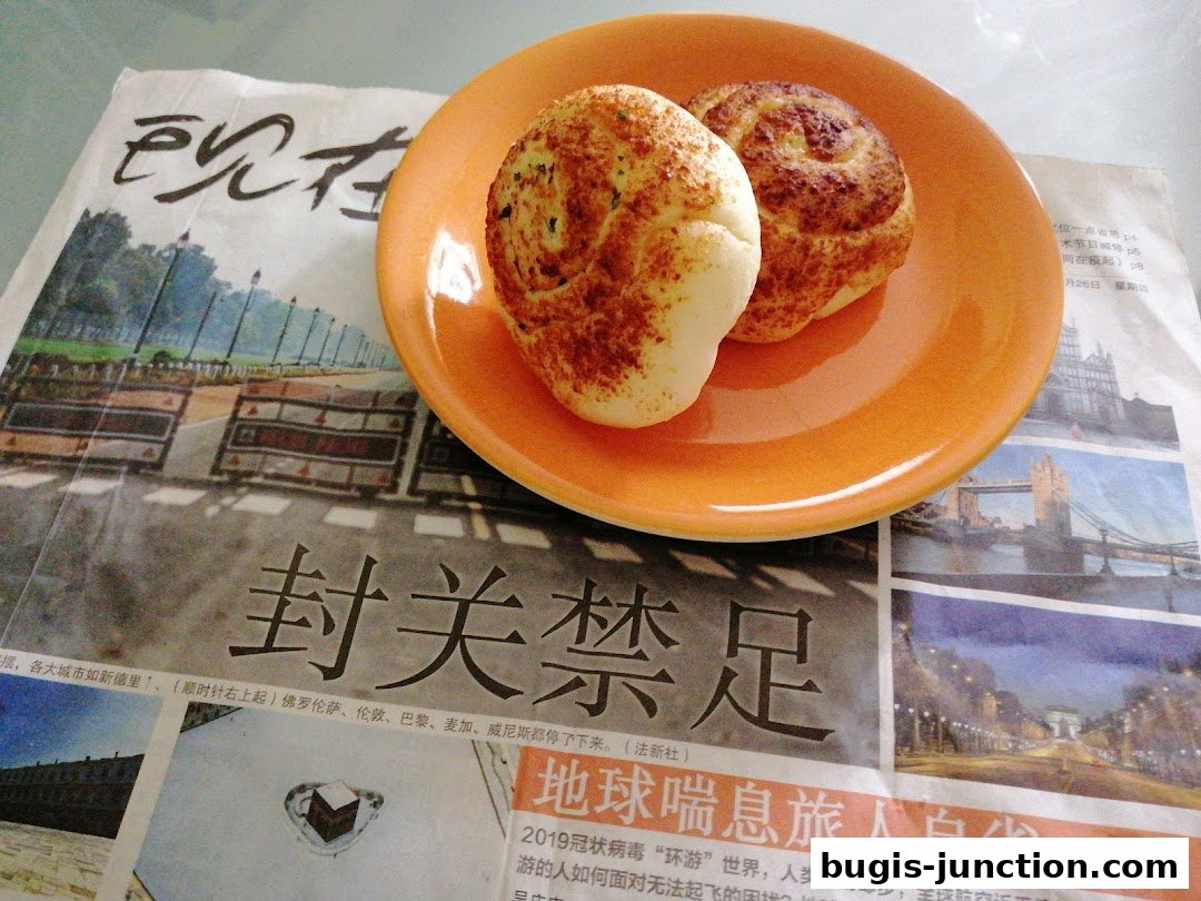 Two baked goods on an orange plate placed on a newspaper with Chinese text and images.