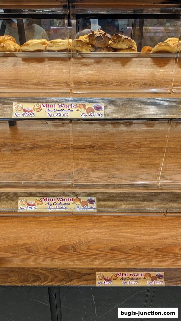 Display shelves with various baked goods and pricing labels for 'Mini World'.