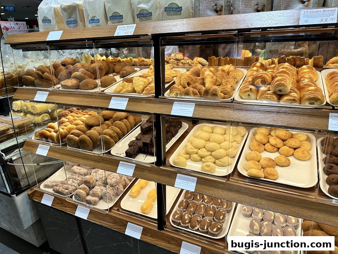 A display of various baked goods including bread, pastries, cookies, and cakes in a bakery.