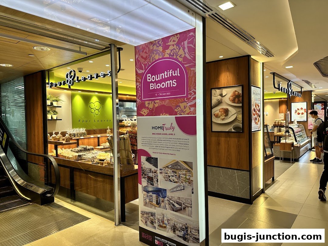 The exterior of a bakery shop named Four Leaves, showcasing its display of baked goods.
