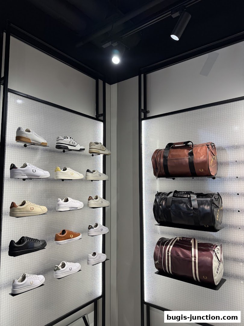 Fred Perry store interior showcasing a variety of sneakers and duffel bags on display.