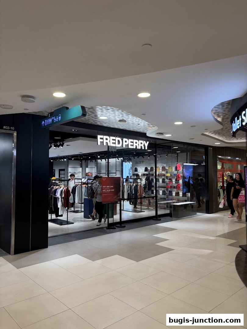 The Fred Perry store at Bugis Junction features a modern storefront with clothing displays and bags.