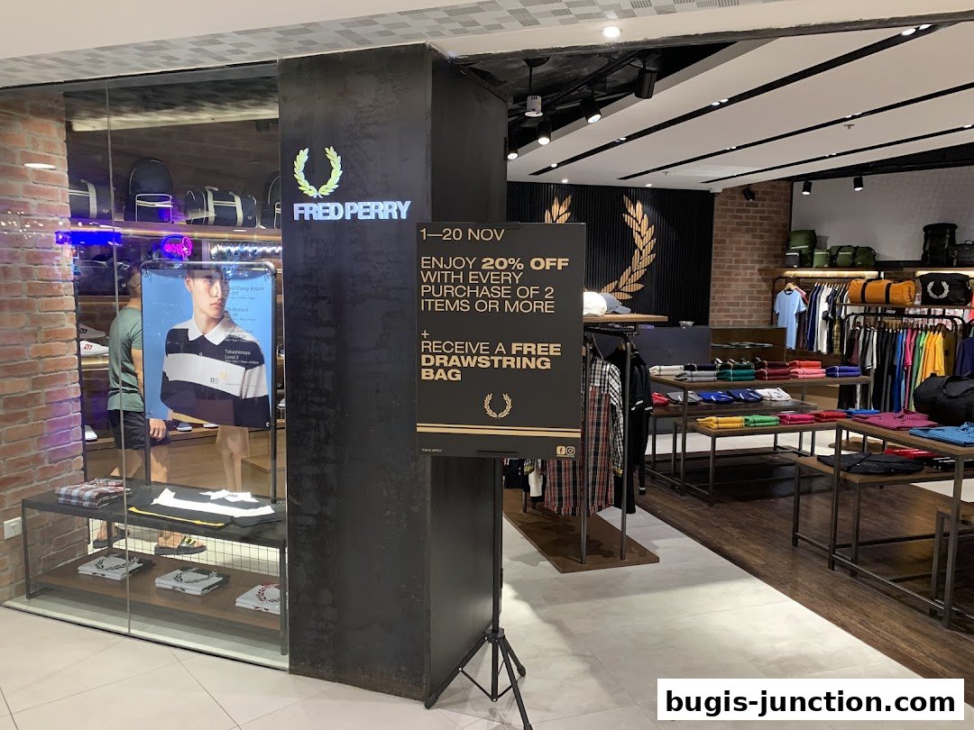 Interior of a Fred Perry store showcasing clothing and a promotional sign.