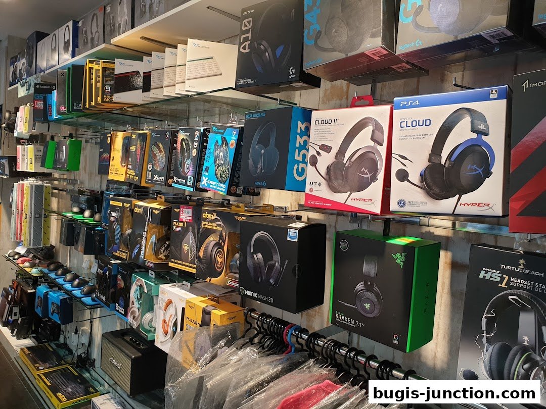 A retail store shelf displaying various gaming headsets and computer accessories.