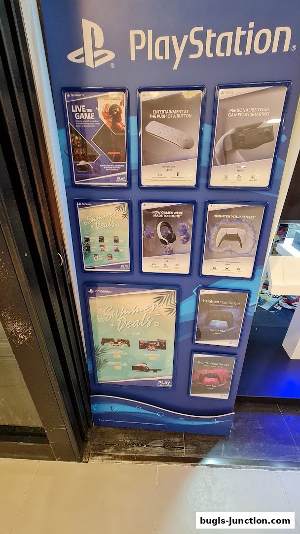 A display board showcasing PlayStation products and summer deals.