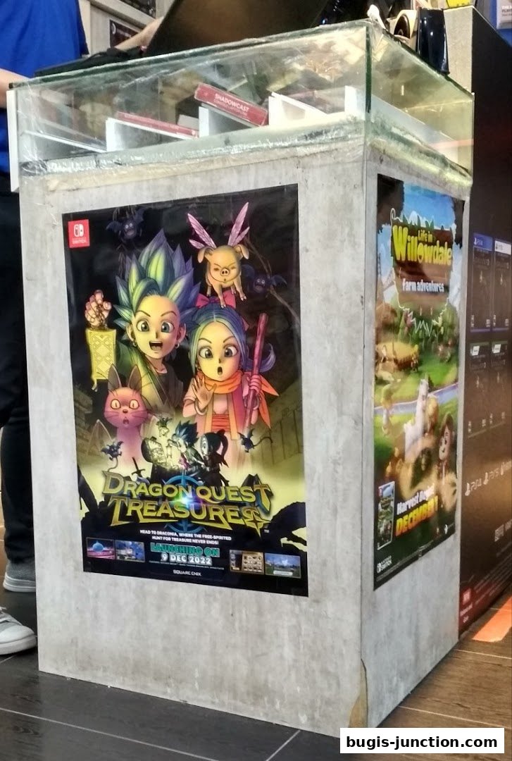 A display stand featuring game advertisements for Dragon Quest Treasures and Life in Willowdale.