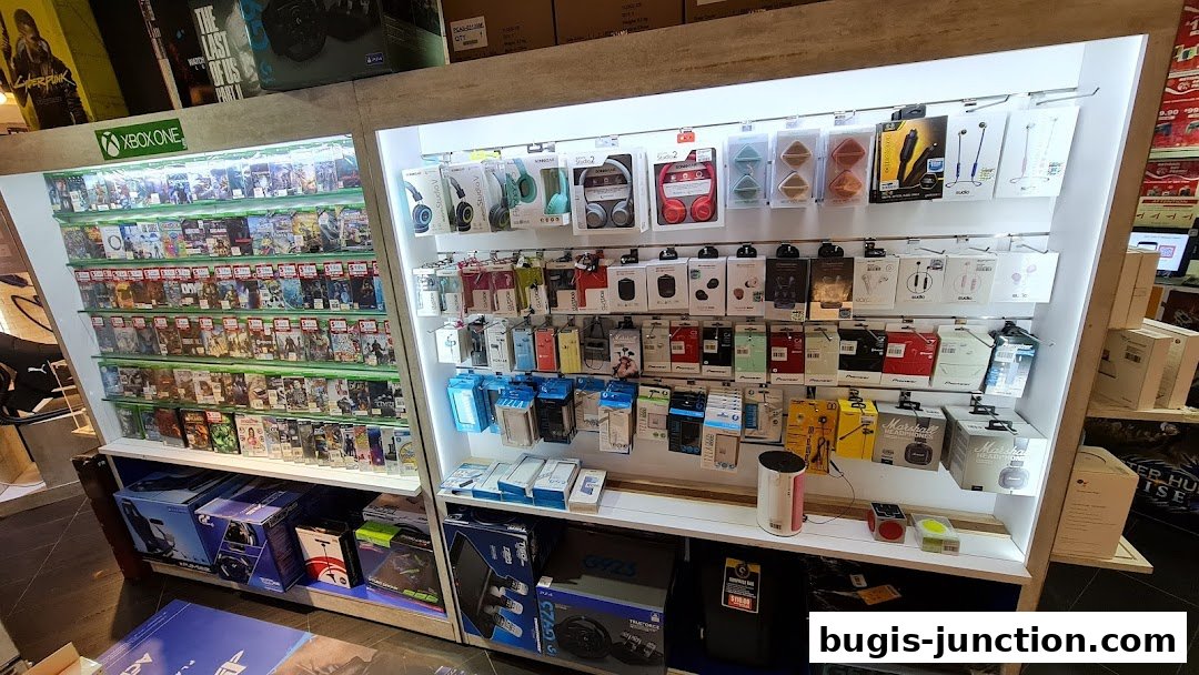A retail store display featuring video games, headphones, and gaming accessories.