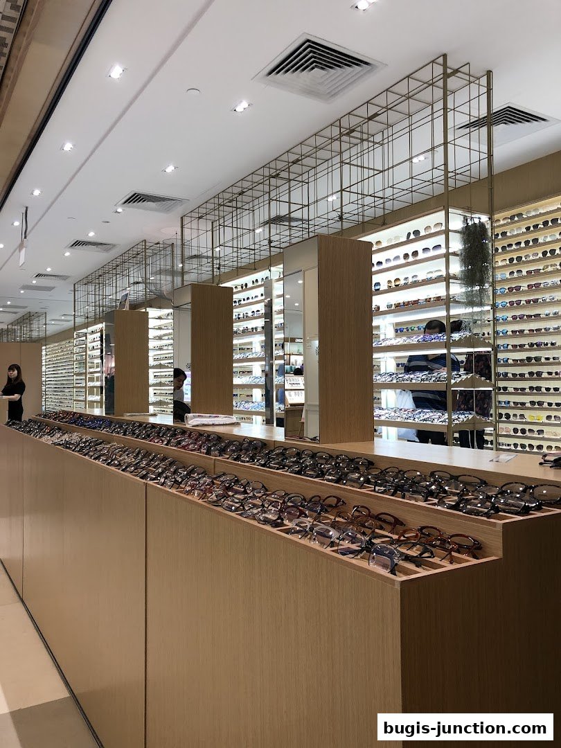 A well-lit eyewear shop interior showcasing a wide selection of sunglasses and eyeglasses.