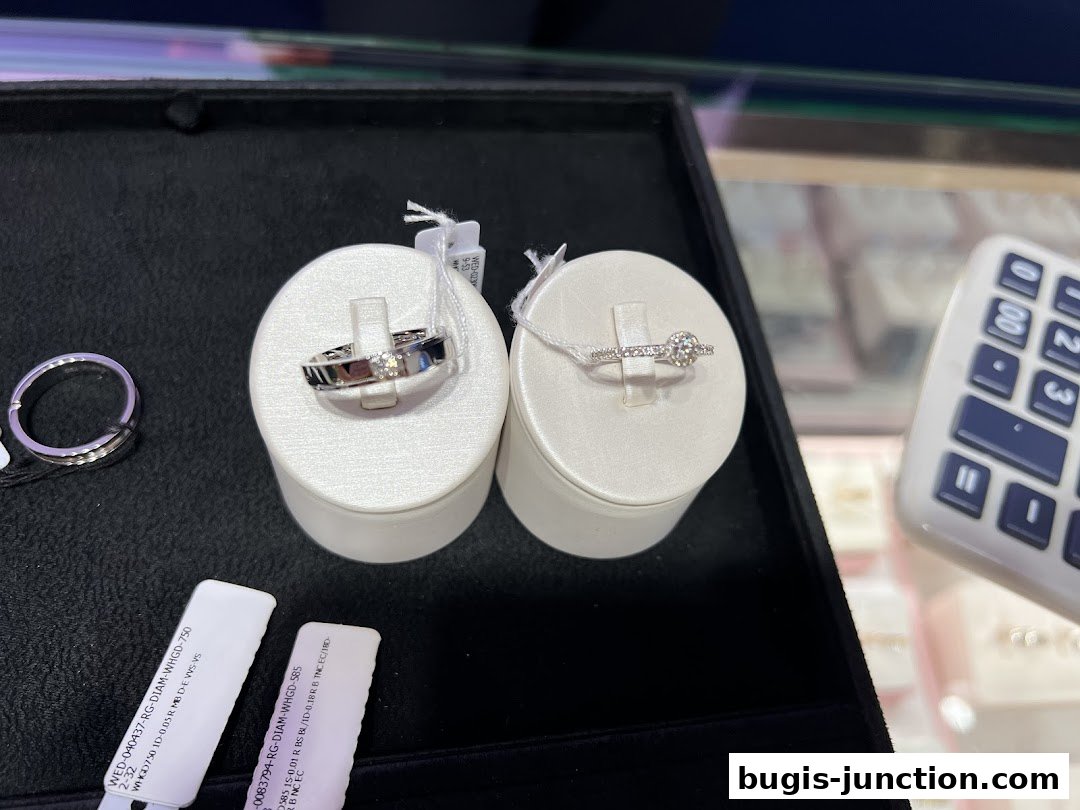A display of diamond rings, including engagement rings and wedding bands, with price tags.
