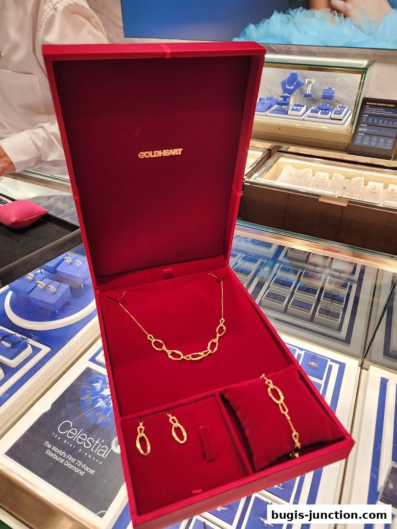 A red jewelry box displays a gold necklace, earrings, and bracelet.