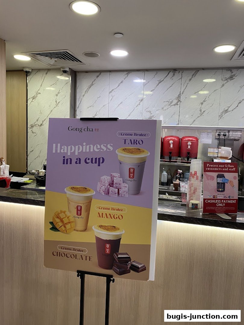 A sign advertising Gong Cha's Creme Brulee drinks in Taro, Mango, and Chocolate flavors.