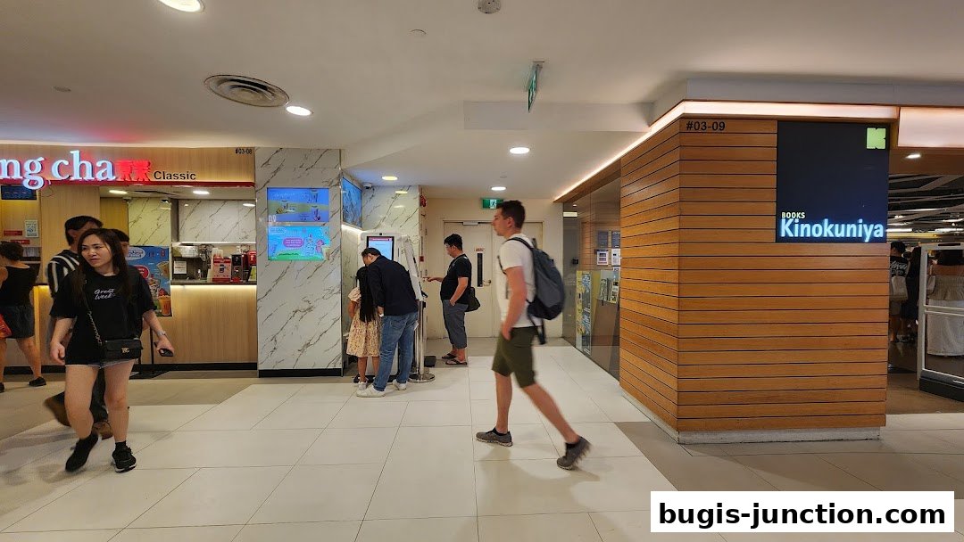 People walk past a Gong Cha Classic bubble tea shop and a Kinokuniya bookstore.