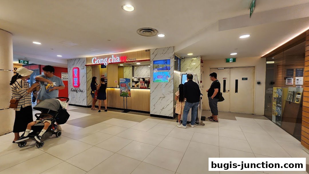 People queuing at the Gong Cha Classic bubble tea shop counter and ordering kiosk.