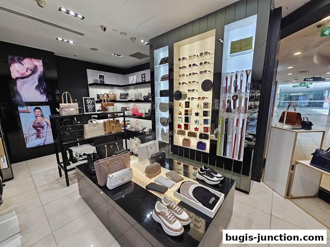 Interior view of a Guess Accessories store showcasing handbags, sunglasses, belts, and shoes.