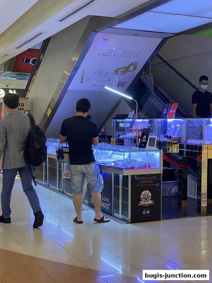 A jewelry store display with various items and a sign advertising diamond customization.
