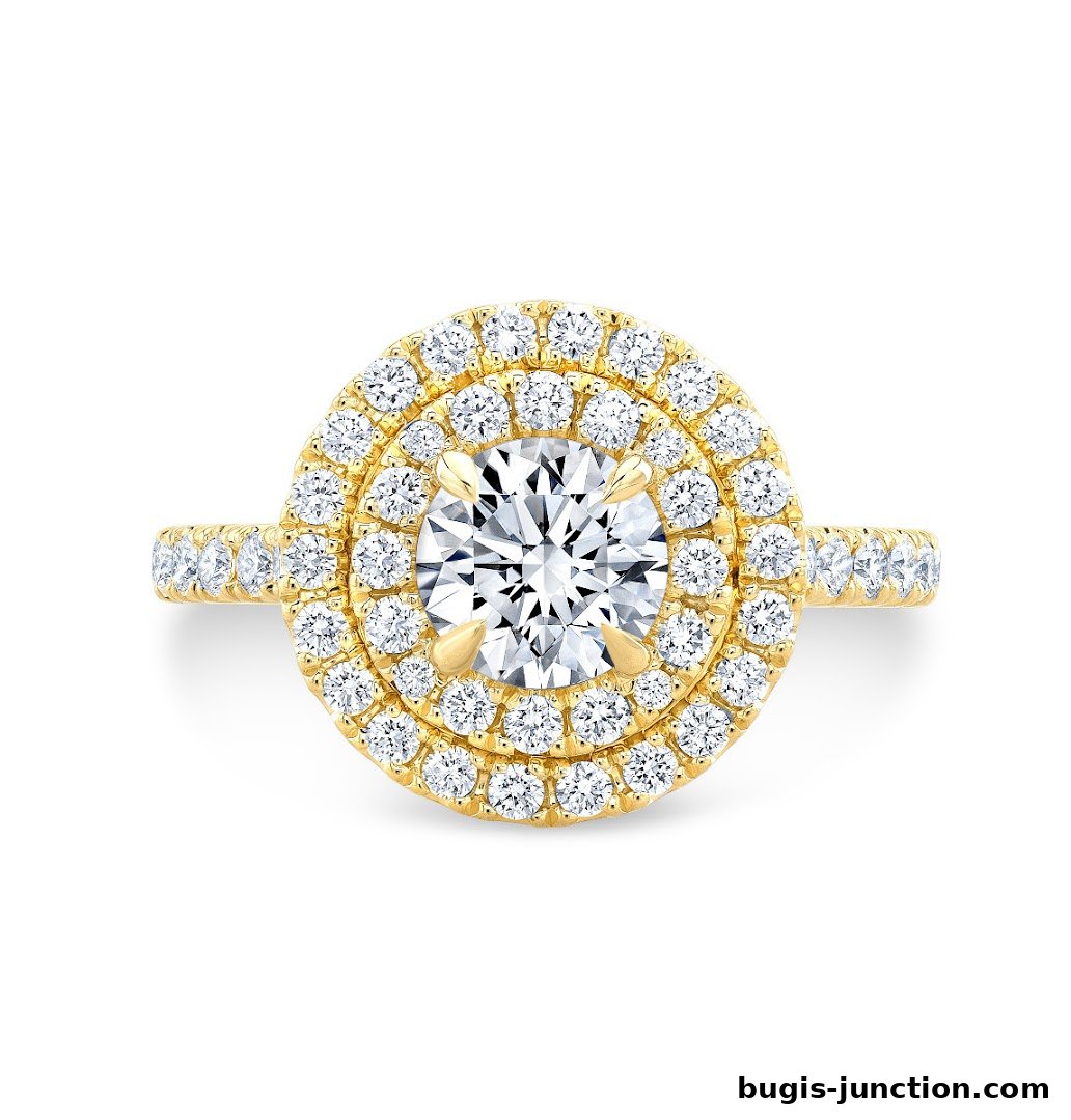 A stunning yellow gold engagement ring with a central diamond surrounded by a double halo of smaller diamonds.