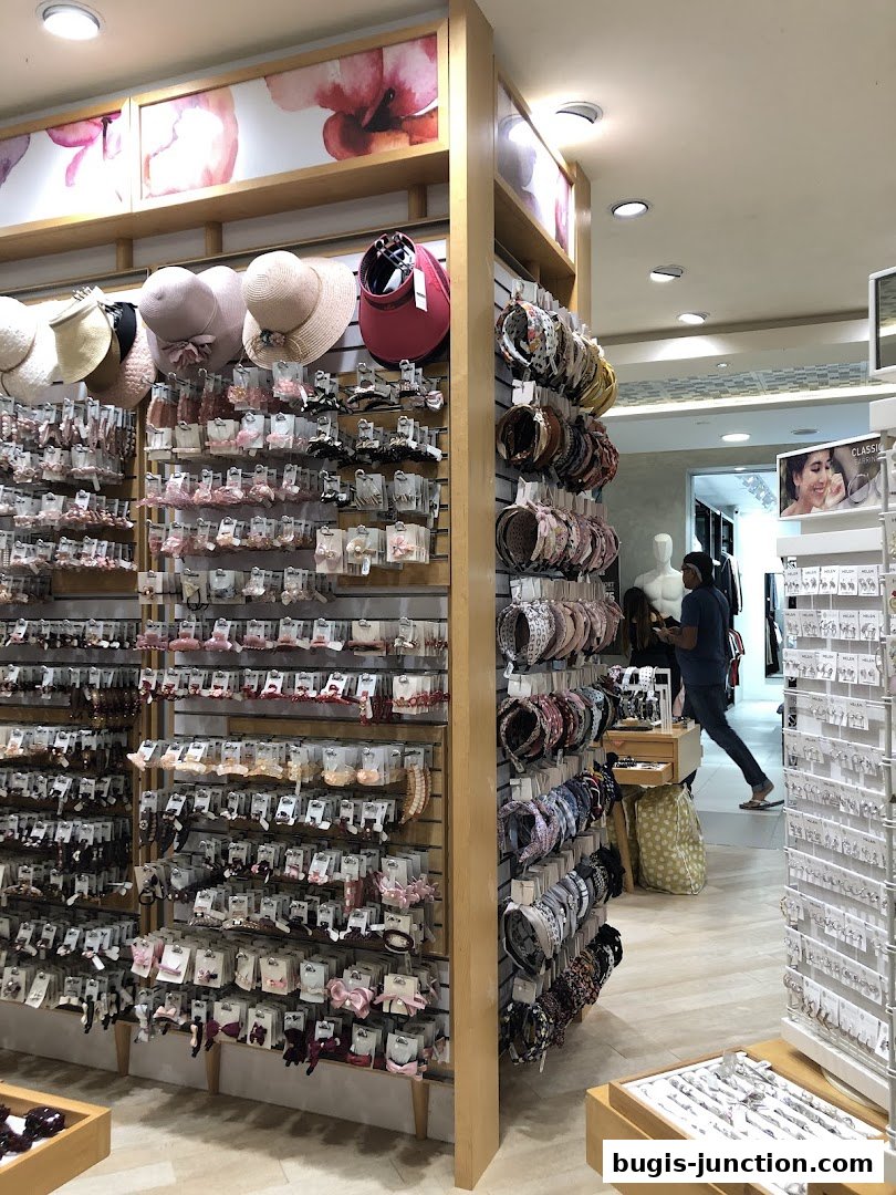 A retail shop interior displaying a wide variety of hair accessories and hats.