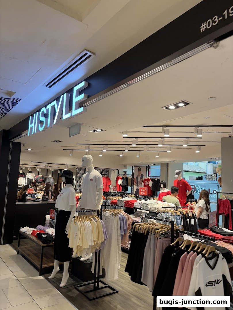 Interior view of a clothing store with mannequins and racks of apparel.