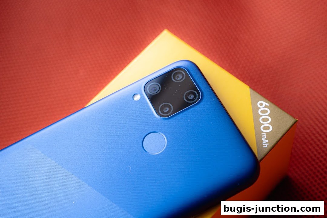 A blue smartphone with a quad-camera setup rests on a yellow box with '6000 mAh' text.