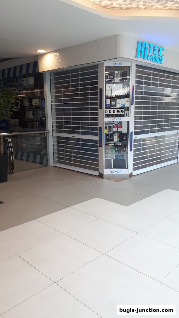 The Hitec Mobile shop front with its roller shutters down, displaying Honor products.